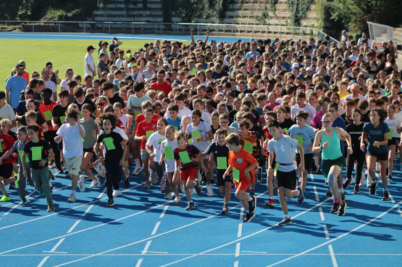 eine Gruppe von Kindern und Jugendlichen in Sportkleidung, die gerade loslaufen